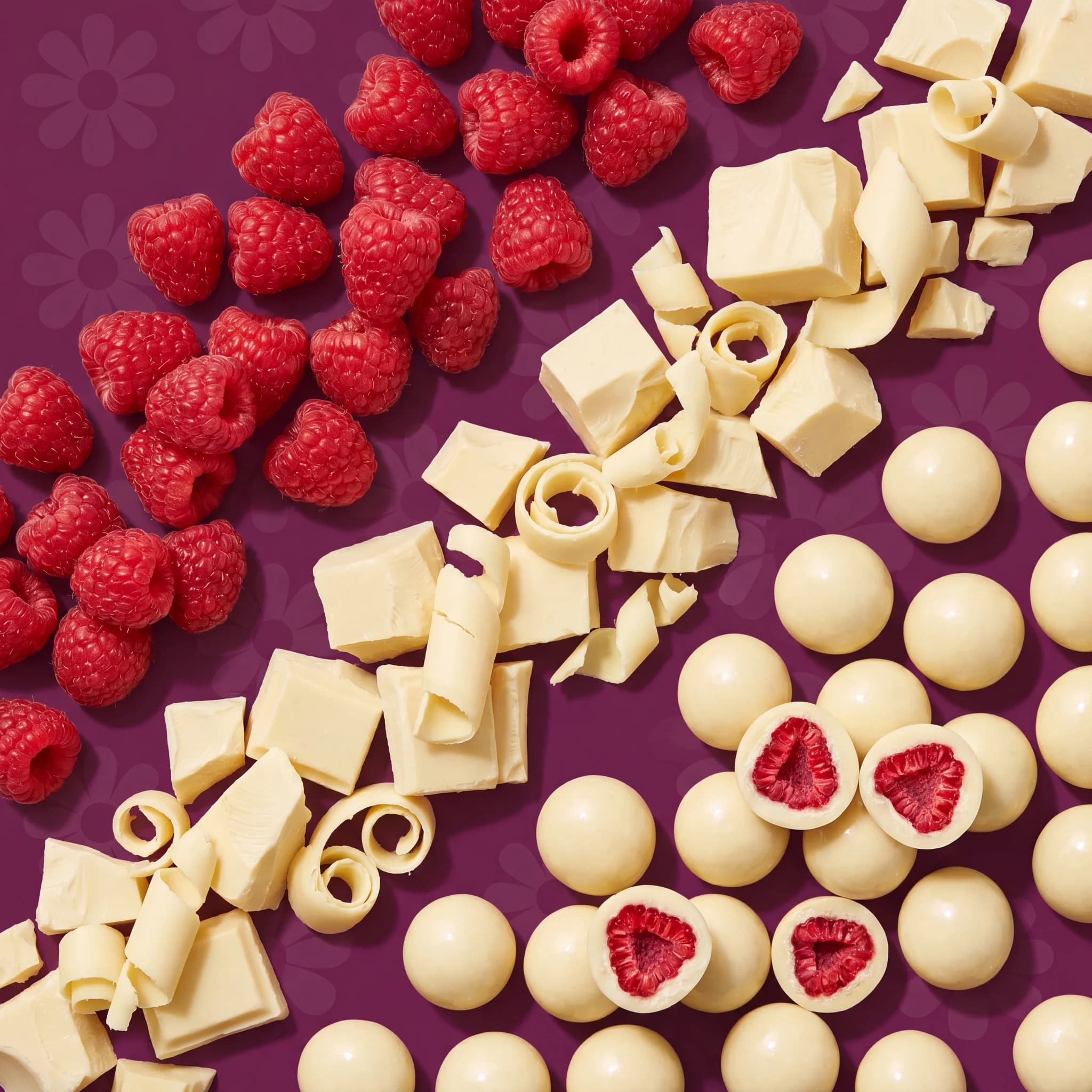 Raspberries, white chocolate curls and cut bites laid out on plum