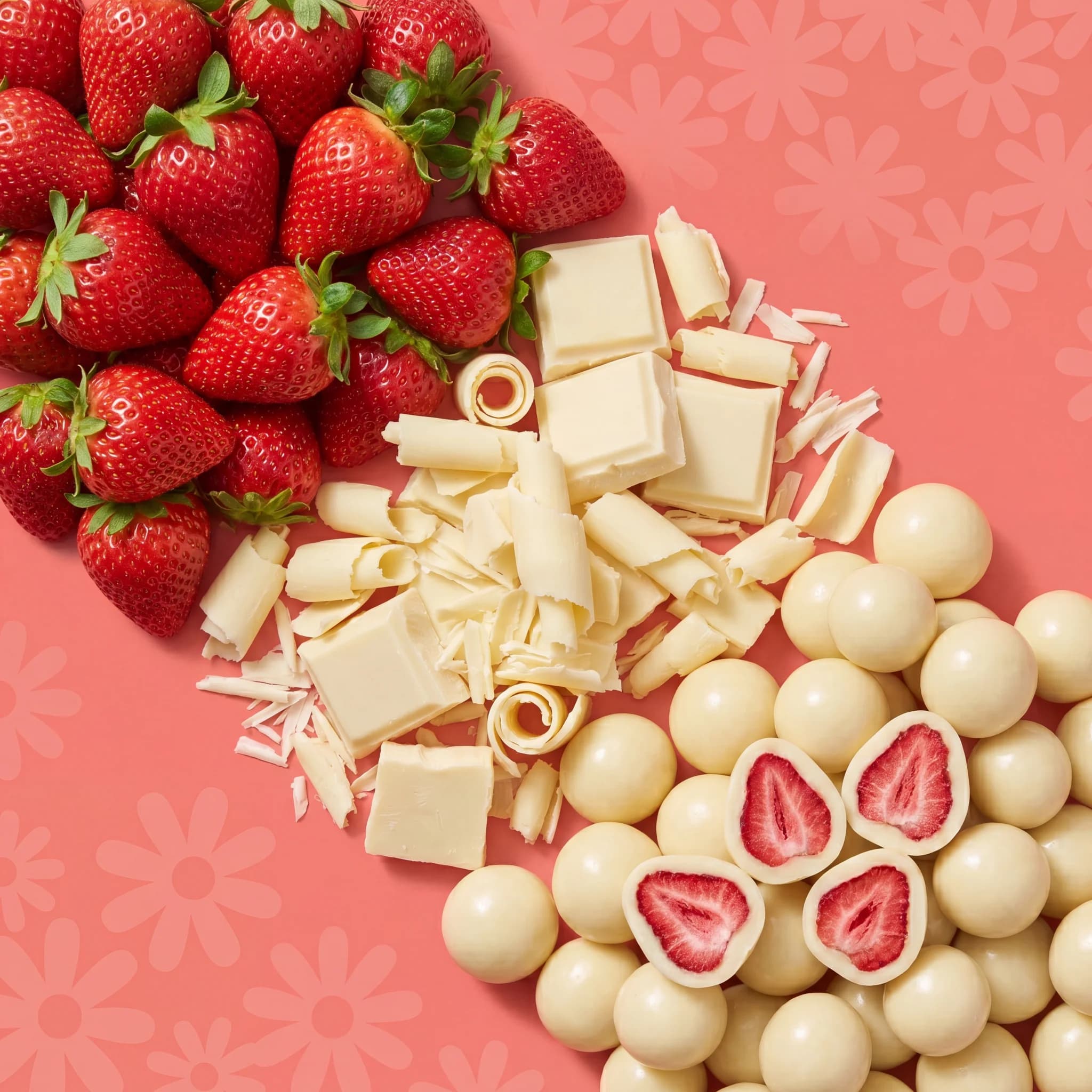 Whole strawberries, white chocolate pieces and finished bites laid out in diagonal bands on coral